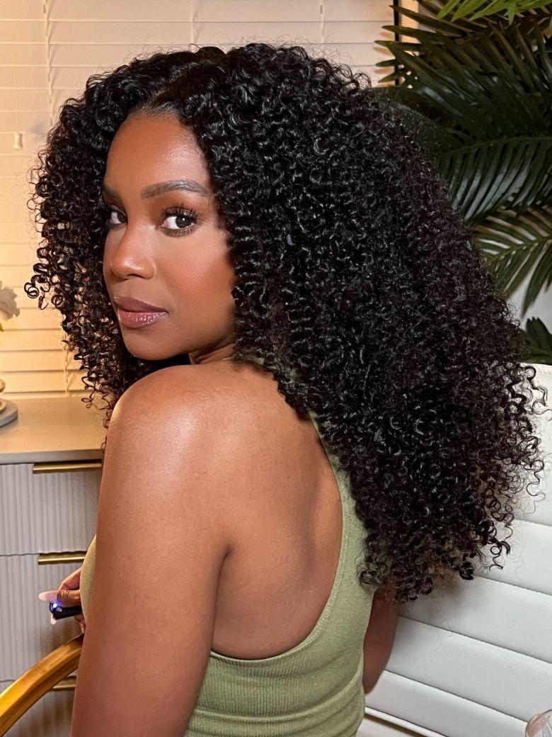 A model displays the UNice 7x5 Bye Bye Slip Black Fluffy Kinky Coils Texture Wig with Invisi Drawstring, showing a model with long curly hair and a green tank top.