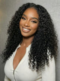 A model displays the UNice Bye Bye Knots 7x5 Lace Jerry Curl 150% Density Wig with Lived-In Coils, showing a model with long curly hair wearing a white sweater and jerry.