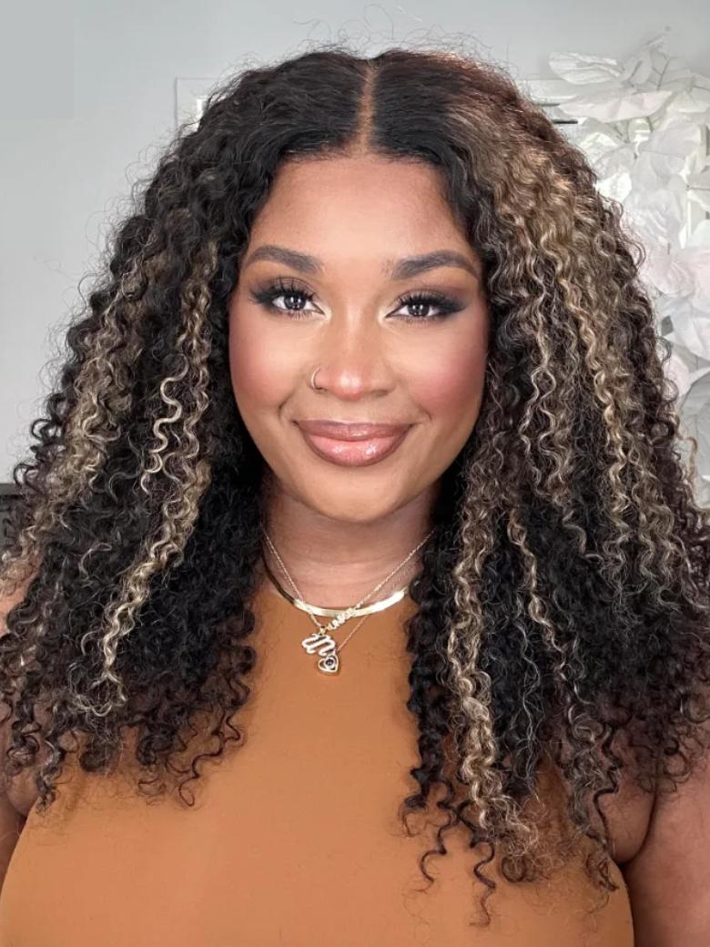 A model displays the UNice 22''=119 Bye Bye Knots Wig 7x5 Glueless Lace Black With Blonde Highlights, showing a model with long curly hair wearing a brown top and kinky.