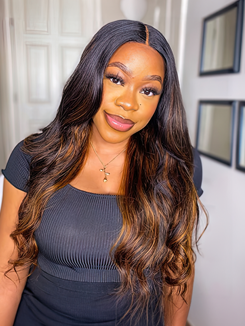 A model displays the UNice Balayage Ombre Highlight Body Wave 4x4 Free Part Lace Closure 1 Piece, showing a model with long hair standing in front of a mirror and body.