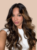 A model displays the UNice Scalp-Friendly V Part Body Wave Shadow Root Balayage Highlight Colored wig, showing a model with long brown hair and a white shirt and body.