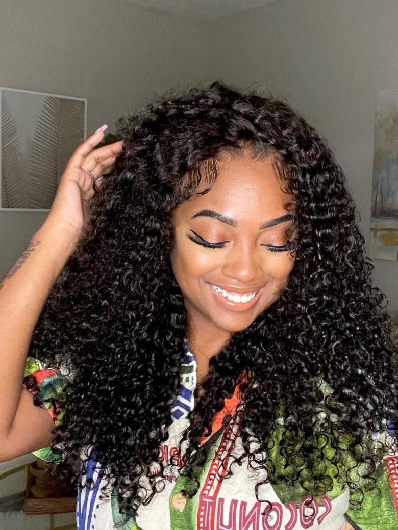 A model displays the UNice 7x5 Bye Bye Knots 150% Density Jerry Curly Wig With Bleached Invisible Knots, showing a model with long curly hair wearing a colorful shirt.