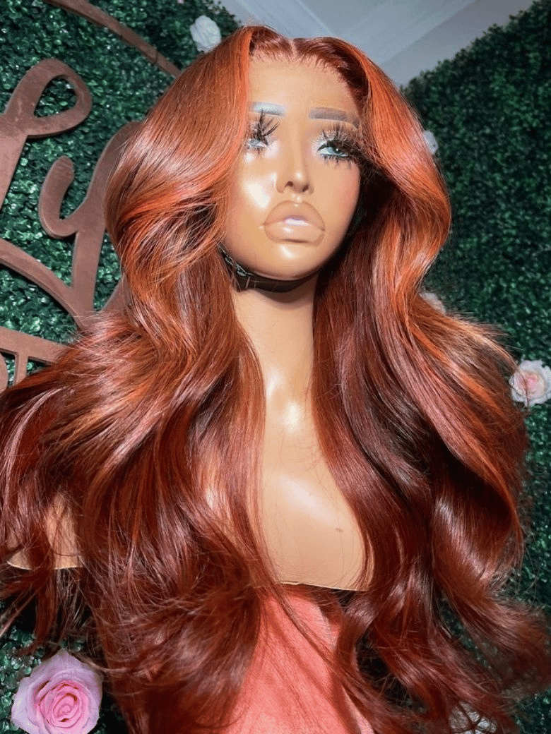 A model displays the UNice 18"-22'' 7x5 Bye Bye Knots Red Orange Highlights Lace Wig with Face Framing, showing a wig with long red hair and a rose and loose wave.