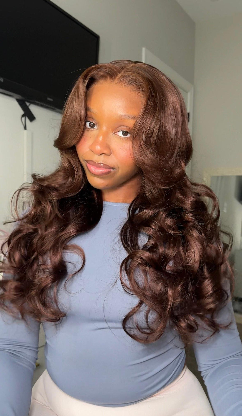 A model displays the UNice 24 Inch BOGO UNice Glueless Auburn Brown13x4 Pre-Everything Lace Frontal Loose, showing a model with long brown hair and a blue shirt.