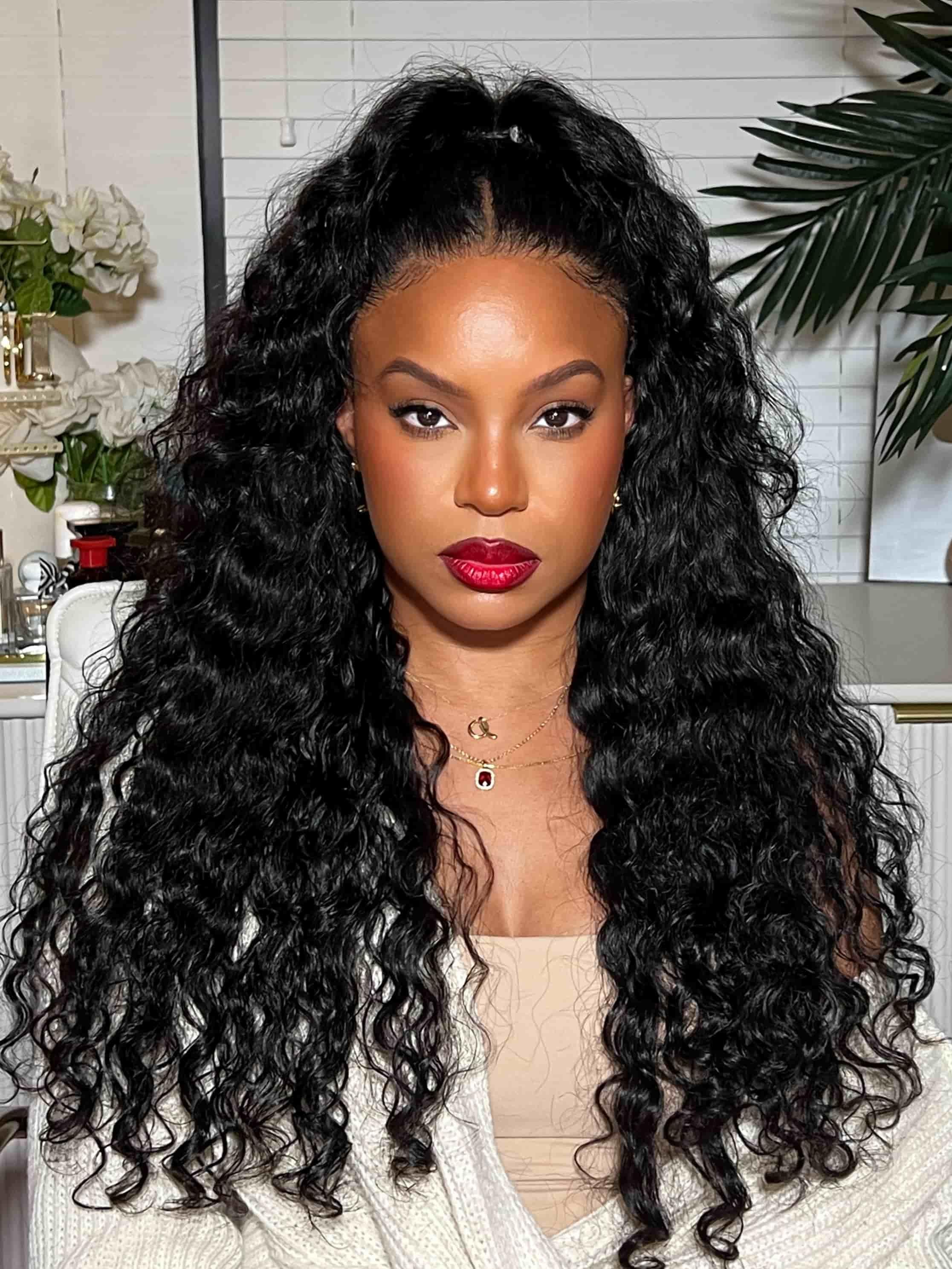 A model displays the UNice 7x5 Bye Bye Knots Wig Quick Glueless & HD Lace Wet & Wavy Water Wave Invisible, showing a model with long curly hair wearing a white sweater.