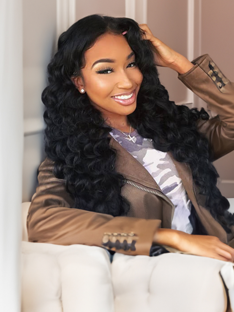 A model displays the UNice Hair Loose Wave Hair Extensions Unprocessed Human Virgin Hair, showing a woman sitting on a couch with a jacket on and loose wave texture.