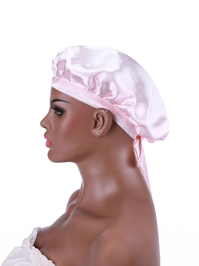 The UNice Bonus Buy Adjustable Satin Pink Night Cap Sleeping Hat For Making wig visual image position 3 shows a woman wearing a pink hat with a bow.
