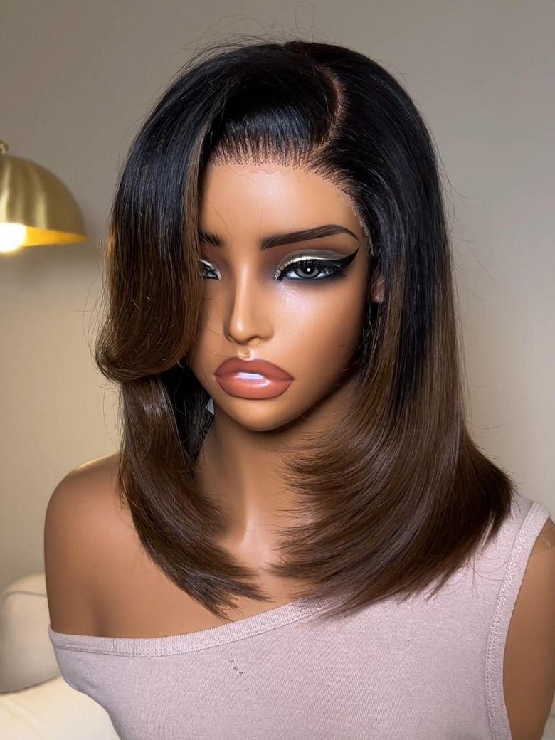 A model displays the UNice Bye Bye Slip 7x5 Lace Warm Brown with Beige Blonde Ribbon Highlights Layered wig, showing a model with blonde hair and a black top sitting.