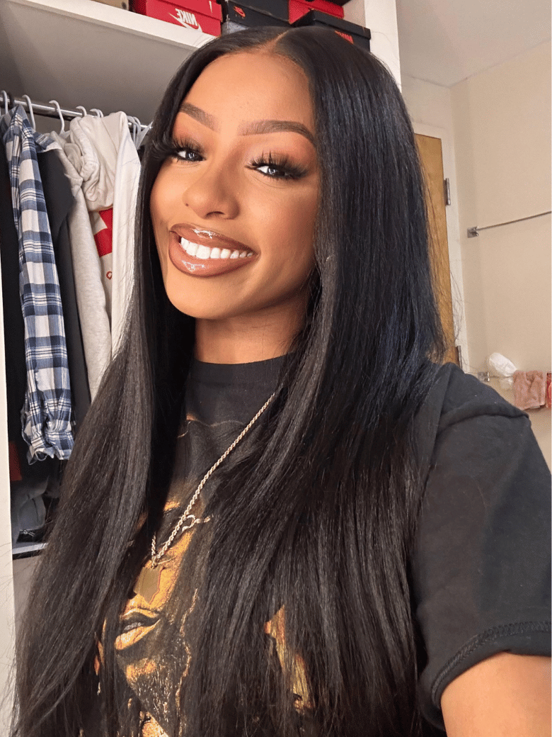A model displays the UNice Ins Only 26" At 24" Price Black Yaki Straight 7x5 Bye Bye Knots Glueless Lace wig, showing a model with long black hair and a black shirt.