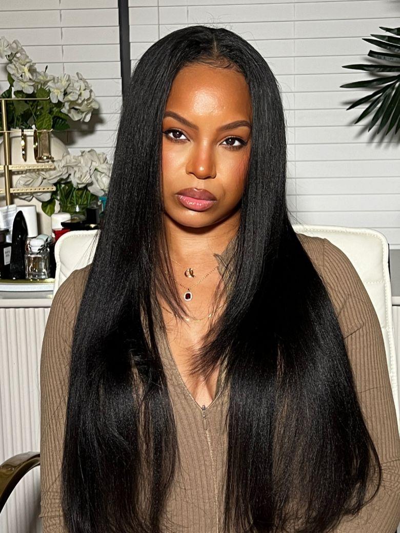 A model displays the UNice EasiContour V Part Glueless Yaki Wig 150% Density, showing a model with long black hair sitting in a chair and yaki texture, glueless wear.