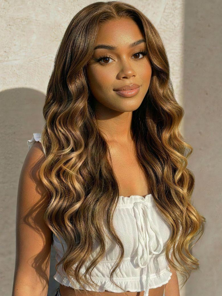A model displays the UNice Bye Bye Slip 7x5 Lace Deep Brown with Caramel Higlights Loose Wave Drawstring wig, showing a model with long wavy hair wearing a white top.