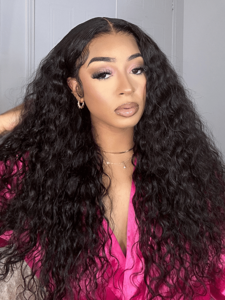 A model displays the UNice With Drawstring 180% Density 13x4 Pre-Everything Lace Front Water Wave Wig, showing a model with long black hair wearing a pink shirt.