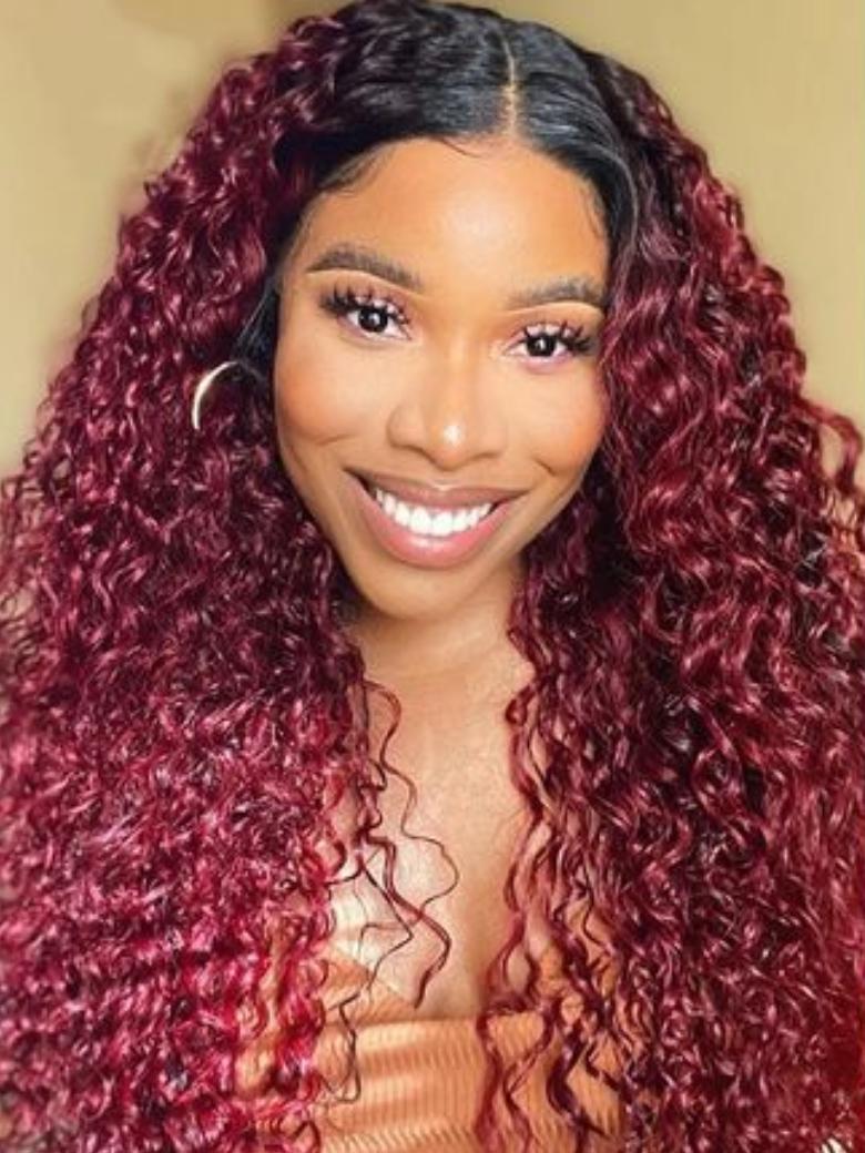 A model displays the UNice Beginner Friendly V Part Burgundy Ombre With Dark Roots Curly Wig 150% Density, showing a model with long curly hair wearing a red wig.