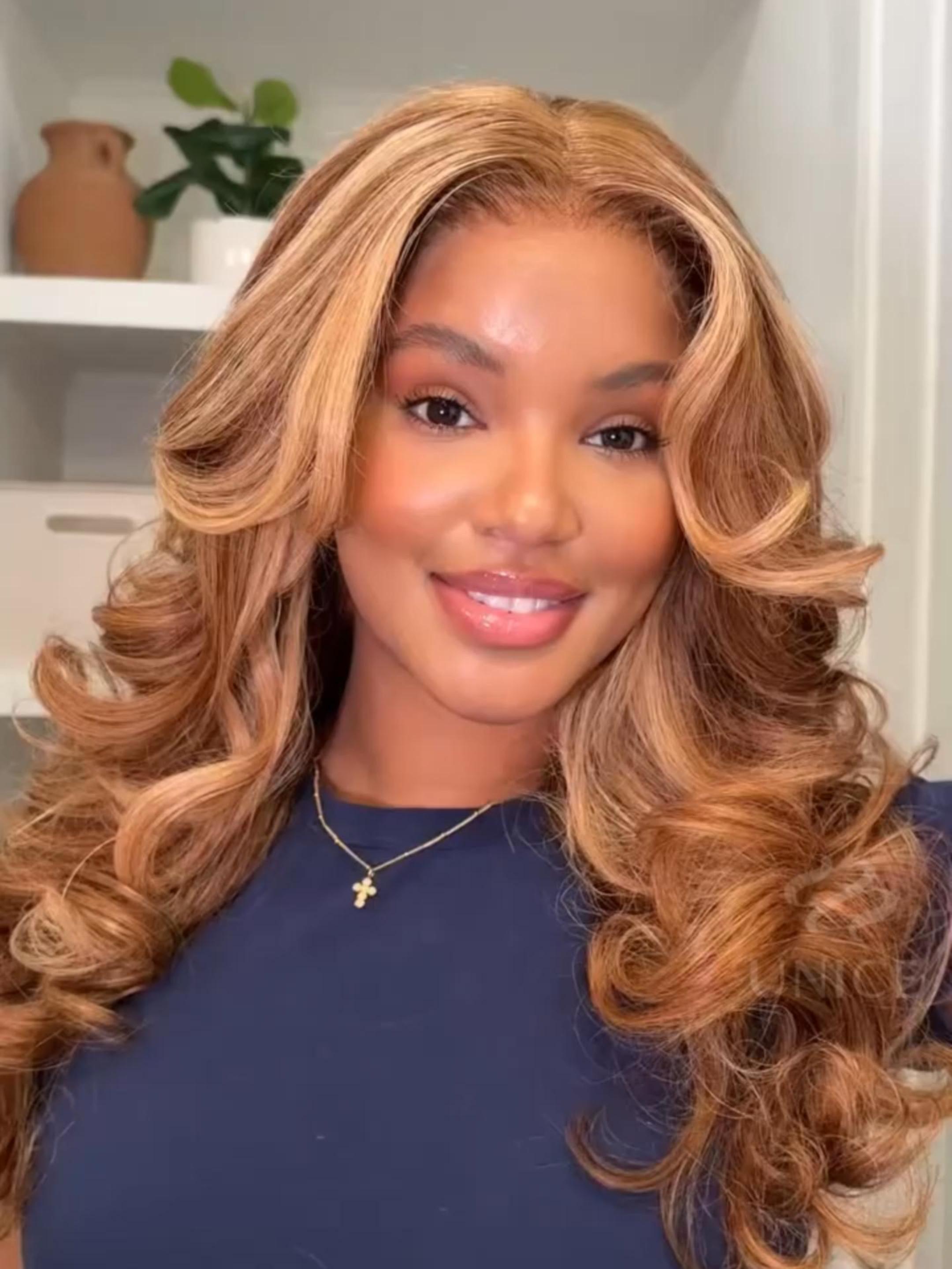 A model displays the UNice 7x5 Bye Bye Knots Wig With Drawstring Pre-Cut Glueless Lace Honey Blonde Body, showing a model with long blonde hair and a blue top and body.
