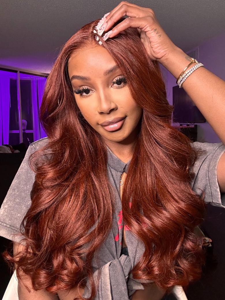 A model displays the UNice Warm and Sophisticated Reddish Brown Hair Paired With Yaki Textur7x5 Upgrade, showing a model with long red hair and a grey shirt and yaki.