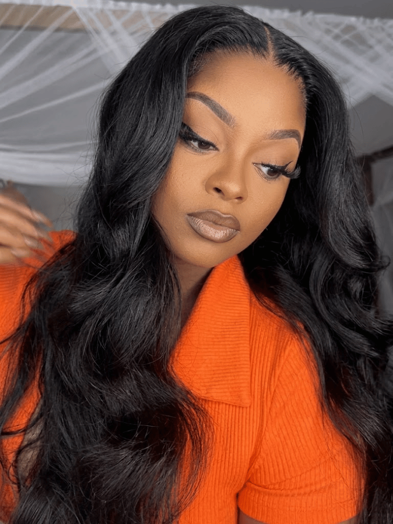 A model displays the UNice 13x4 HD Lace Bye Bye Slip Body Wave Wig - Human Hair Glueless Pull & Go Fit, showing a model with long black hair wearing an orange sweater.