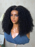A model displays the UNice Bye Bye Slip 7x5 Lace Warm Brown with Beige Blonde Ribbon Highlights Layered wig, showing a model with blonde hair and a black top sitting.