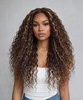 A model displays the UNice Invisi Drawstring " Bye Bye Knots 7x5 Lace Dark Toffee Brown with Auburn wig, showing a model with long curly hair wearing a white top.