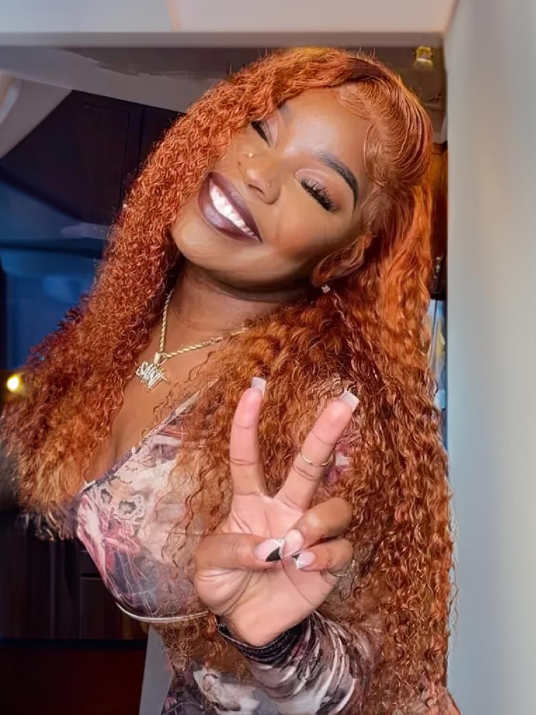A model displays the UNice Hot Ginger Color Glueless Lace Jerry Curly Human Hair Lace Part Wig 150% Density, showing a model with long red hair and jerry curl texture.