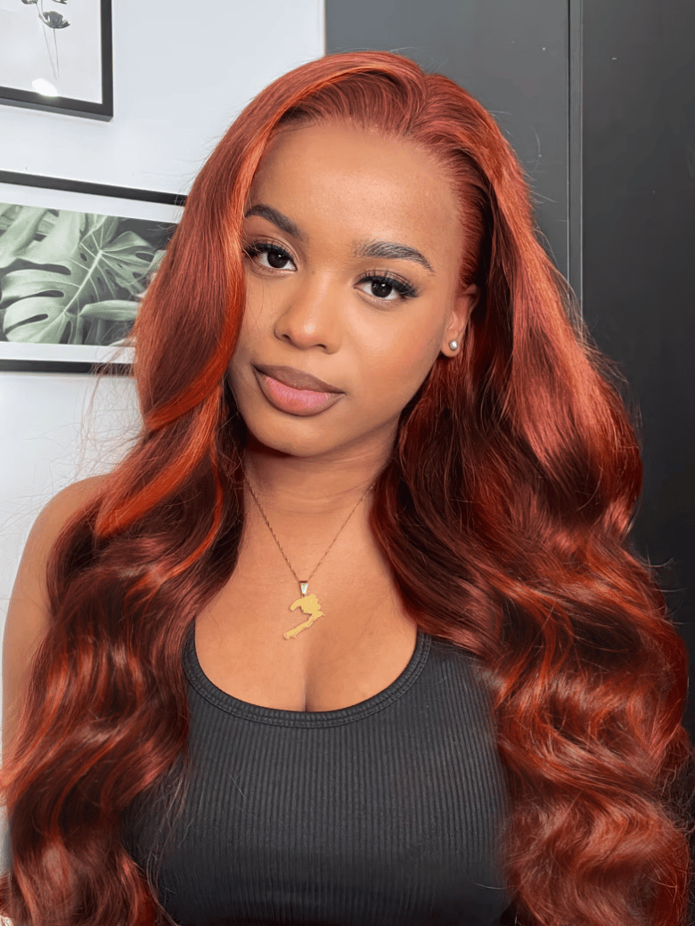 A model displays the UNice 7x5 Bye Bye Knots Red Orange Highlights Lace Wig with Face Framing Layers, showing a model with long red hair and a black top and loose wave.