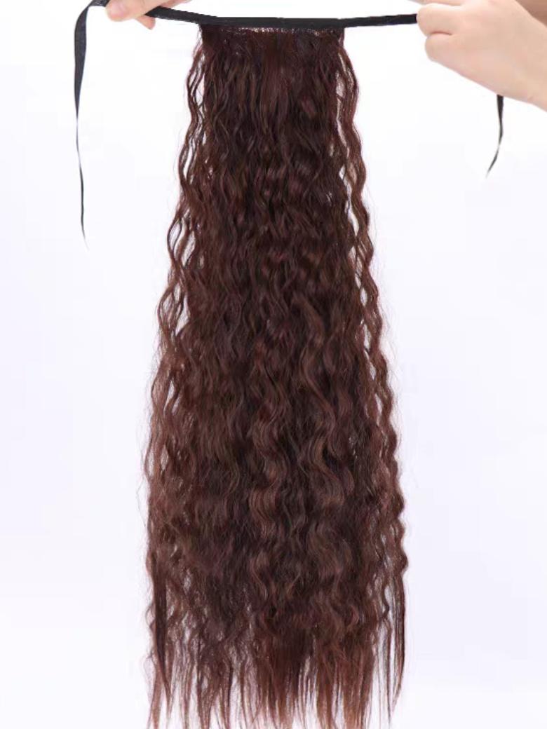 A model displays the UNice Machine-Made Dark Brown Deep Wave Clip-In Ponytail Extension, showing a model is holding a piece of hair and deep wave texture.