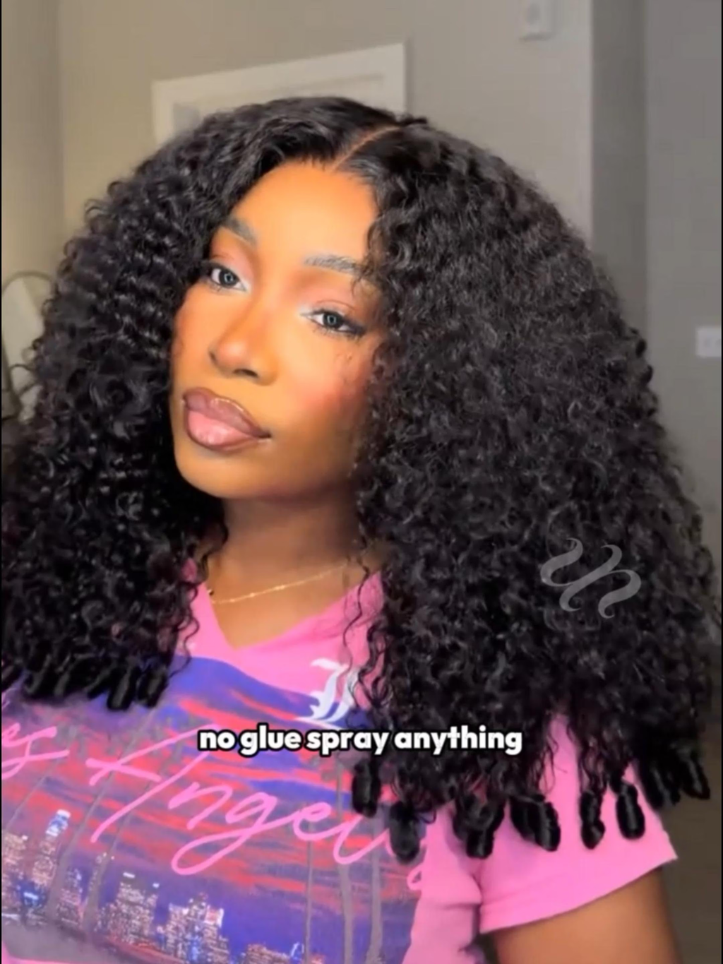 A model displays the UNice 13x4 Pre-Everything Curly Texture Premium Hair Drawstring Wig With Finger Coil, showing a model with long curly hair wearing a pink shirt.