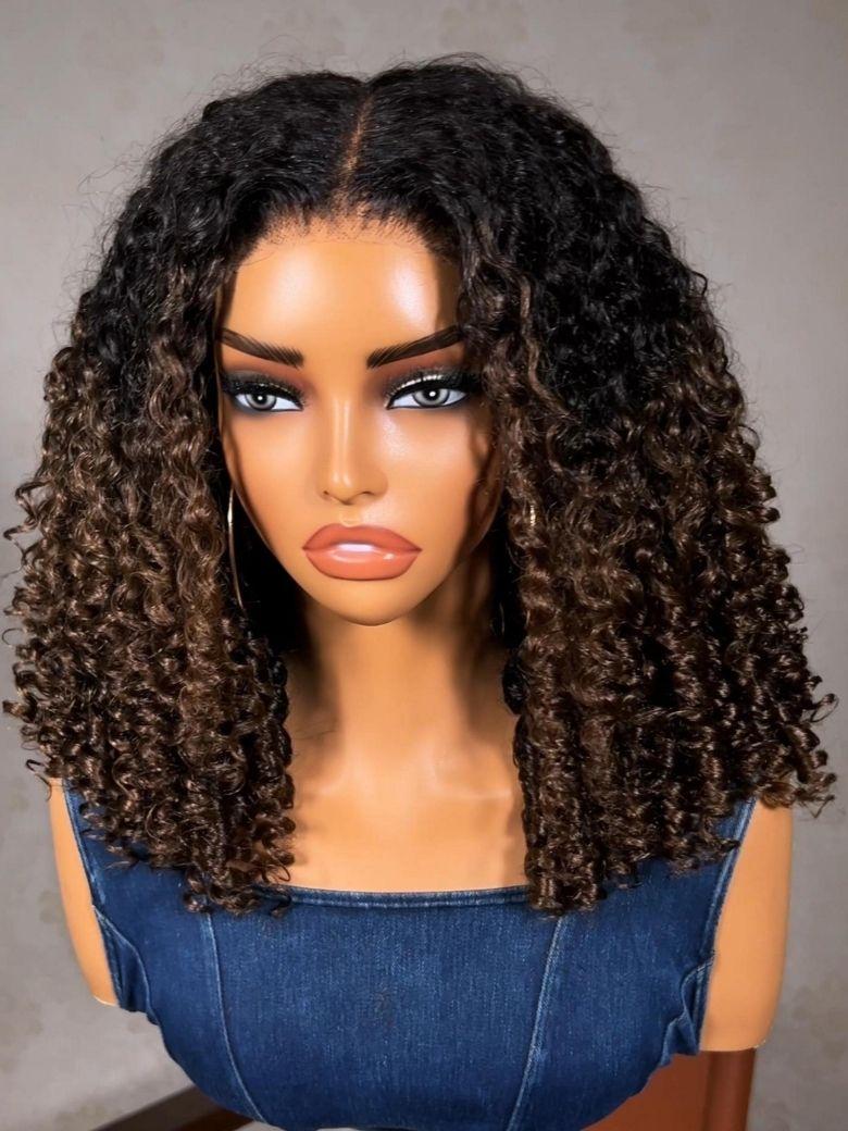 A model displays the UNice Bye Bye Slip 7x5 Lace Warm Brown with Beige Blonde Ribbon Highlights Layered wig, showing a model with blonde hair and a black top sitting.