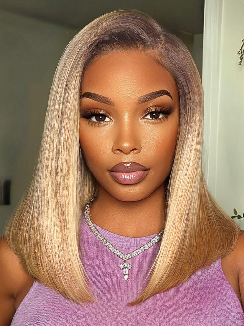 A model displays the UNice Bye Bye Slip 7x5 Lace Blonde with Brown Roots Side Part Blunt Bob Drawstring wig, showing a model with blonde hair and a purple top and 7x5.