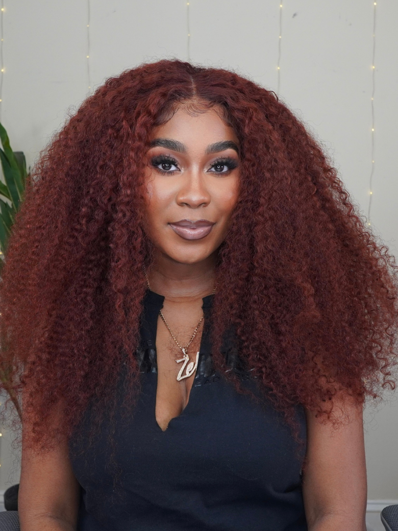 A model displays the UNice 7x5 Bye Bye Knots Wig Glueless Lace Sunset Kinky Curly for Reddish Brown Wig, showing a model with long red curly hair and kinky curly.