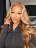 A model displays the UNice 7x5 Bye Bye Slip Wig With Drawstring Pre-Cut Glueless Lace Honey Blonde Body, showing a model with long blonde hair wearing a black jacket.