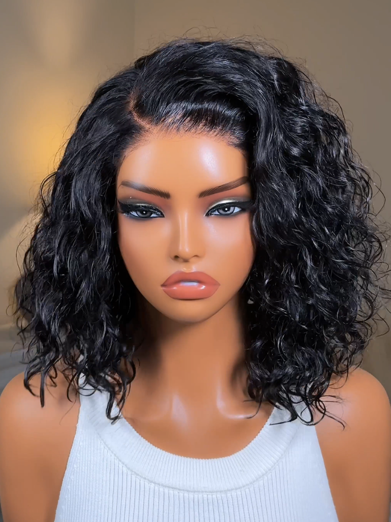 A model displays the UNice Bye Bye Slip 6X4 Glueless Lace "C" Side Part Loose Wavy Bob Drawstring Wig For, showing a model with long curly hair wearing a white top.