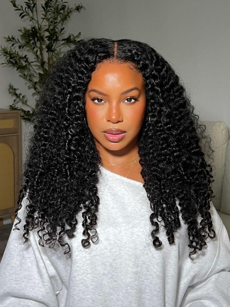 A model displays the UNice 20"-24" UNice Bye Bye Knots 7x5 Lace & 13x4 Pre-Everything Curly Texture wig, showing a model with long curly hair and a grey sweatshirt.