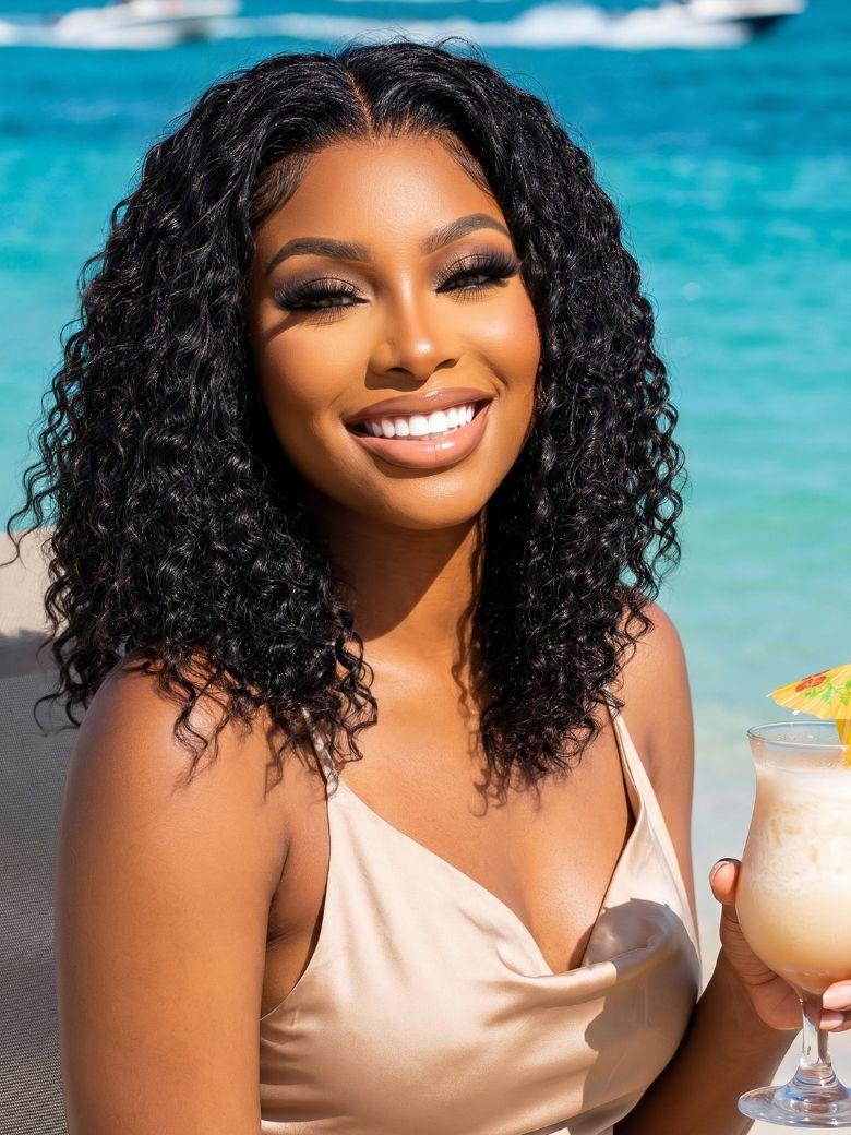 A model displays the UNice 7x5 Bye Bye Slip Lace Frontal Black Soft Wet-Look Twist-Out Inspired Curls, showing a woman holding a cocktail and smiling and 7x5, glueless.