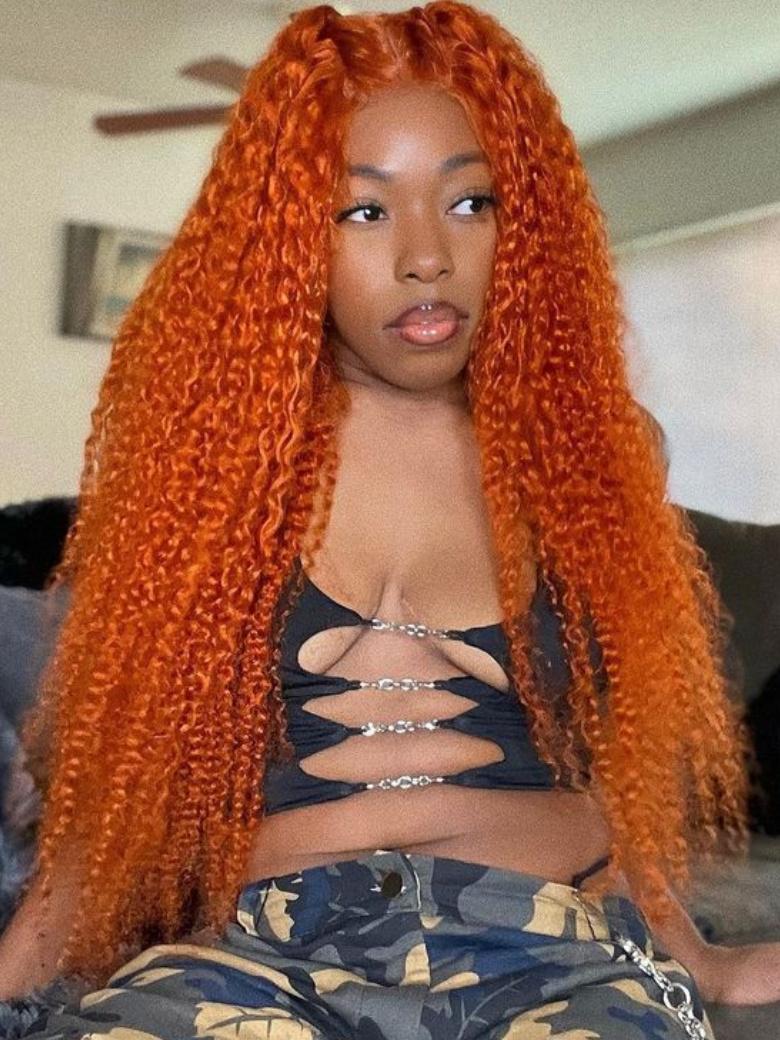 A model displays the Unice Lace Part 150% Density Ginger Color Jerry Curly Human Hair Wig With Invisible, showing a model with long orange hair sitting on a couch.