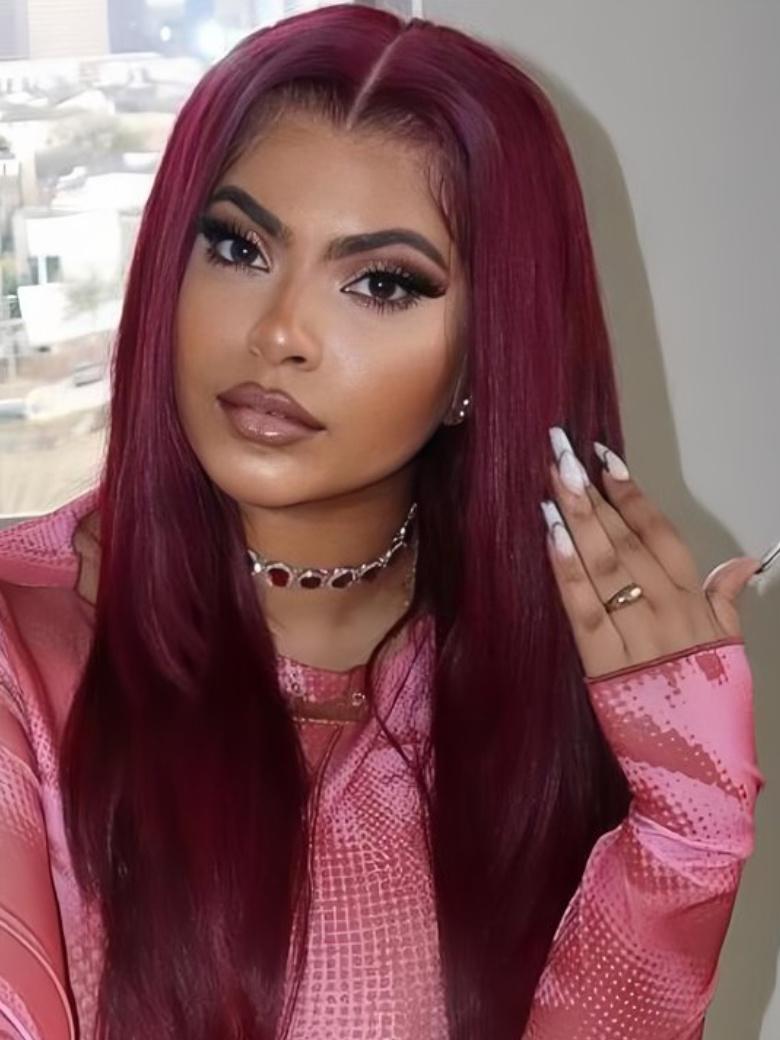 A model displays the UNice Bye Bye Knots Wig 7x5 Glueless Lace Burgundy Yaki Wig With Bleached Knots, showing a model with long red hair and a pink shirt and yaki.