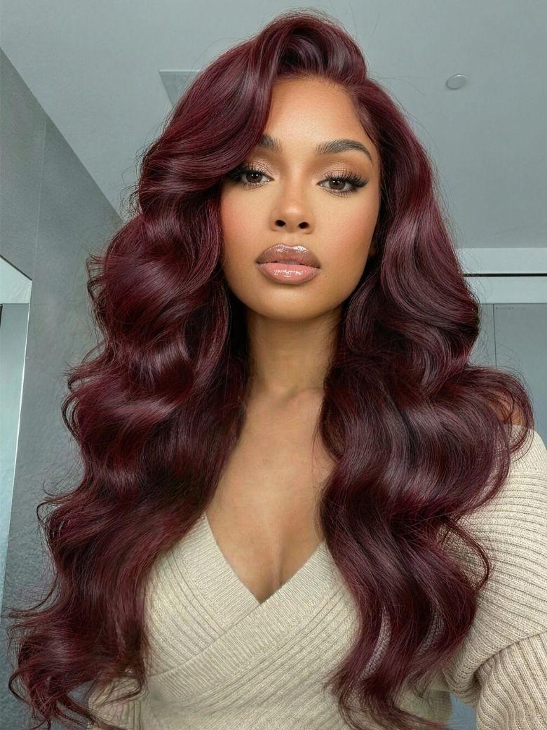 A model displays the UNice Glueless Human Hair Bye Bye Knots 7x5 Lace Dark Auburn Side Part Big Bouncy wig, showing a model with long dark red hair and a white sweater.