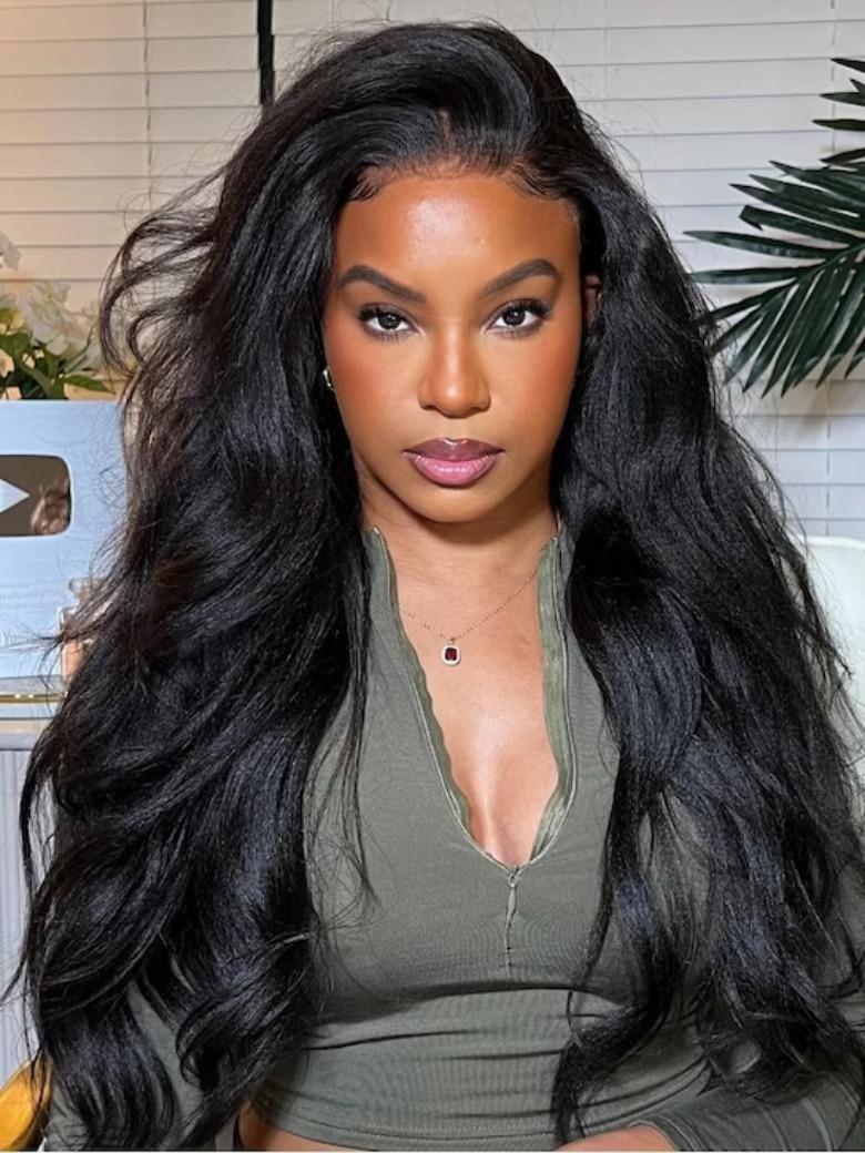 A model displays the UNice Bye Bye Knots 7x5 Natural Lace Black Yaki Wig with Soft Layers & Pre-Plucked, showing a model with long black hair and a green top and yaki.