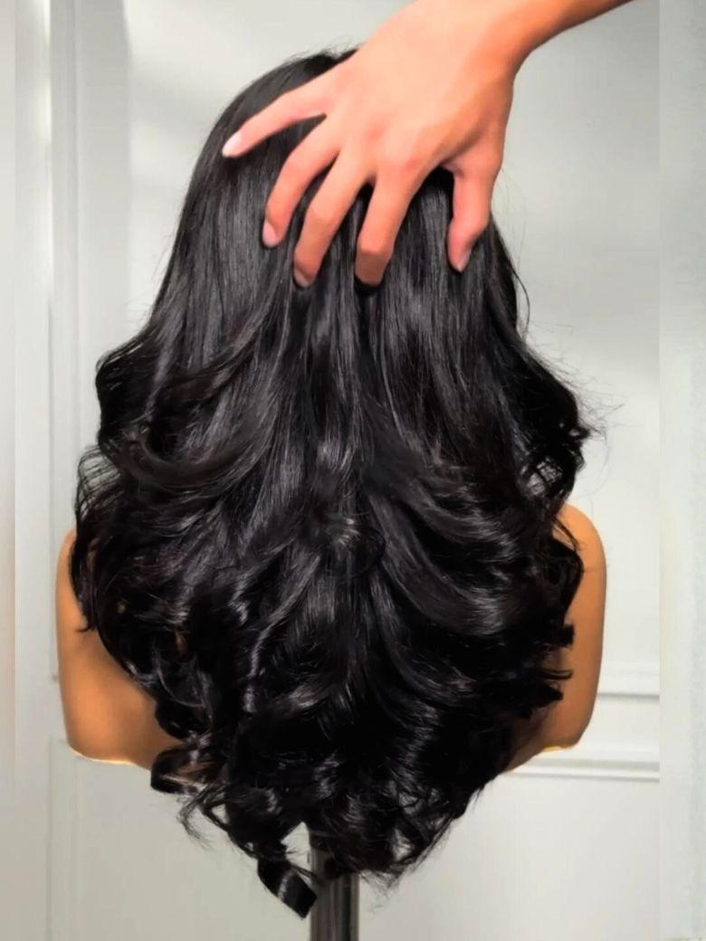 A model displays the UNice Ship within 24H UNice Bye Bye Slip Wig Feathered Layer Left Side Part 200%, showing a model with long black hair is shown from the back.