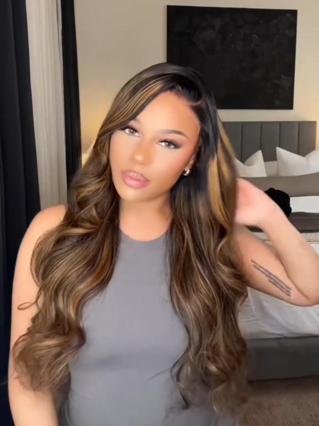A model displays the UNice Limited Quantity UNice 13x4 Lace Frontal Balayage Highlights Body Wave, showing a model with long brown hair and a grey top and body wave.