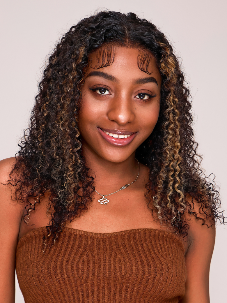 A model displays the UNice 6x4.5 Pre Cut Lace Curly Wig Put On And Go Quick Easy Black With Blonde Highlights, showing a model with curly hair and a brown sweater.