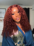A model displays the UNice 7x5 Glueless Lace Bye Bye Knots Wig Sunset Jerry Curly for Reddish Brown, showing a model with long red curly hair and a blue shirt and jerry.