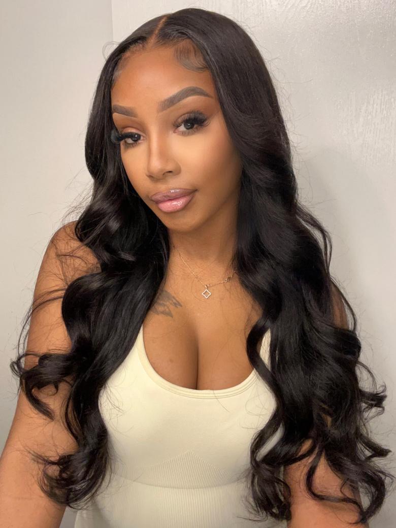 A model displays the UNice Natural Color Body Wave 4x4 Free Part Lace Closure, showing a model with long black hair wearing a white tank top and body wave texture, 4x4.