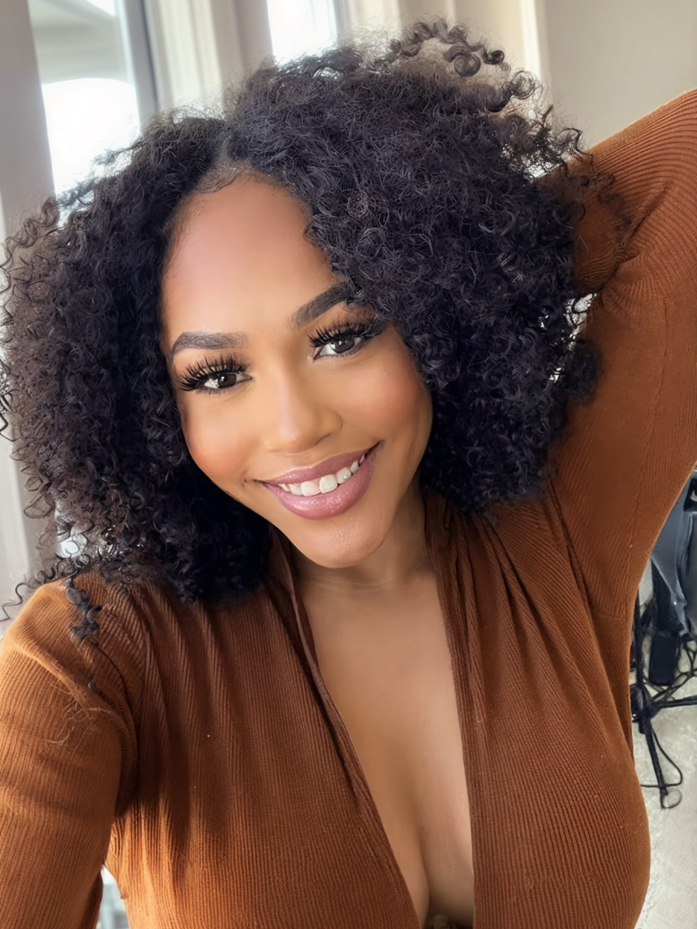 A model displays the UNice New V Part Kinky Curly Glueless 0 Skill Needed Wig, showing a model with curly hair and a brown sweater and kinky curly texture, curly.