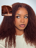 The UNice 7x5 Bye Bye Knots Wig Glueless Lace Sunset Kinky Curly for Reddish Brown Wig visual image position 2 shows a model with long curly hair and a white shirt |.