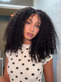 A model displays the UNice 13x4 Bye Bye Slip Glueless Curly Texture Extremely Light Wig With Finger Coil, showing a model with long curly hair standing in a bathroom.