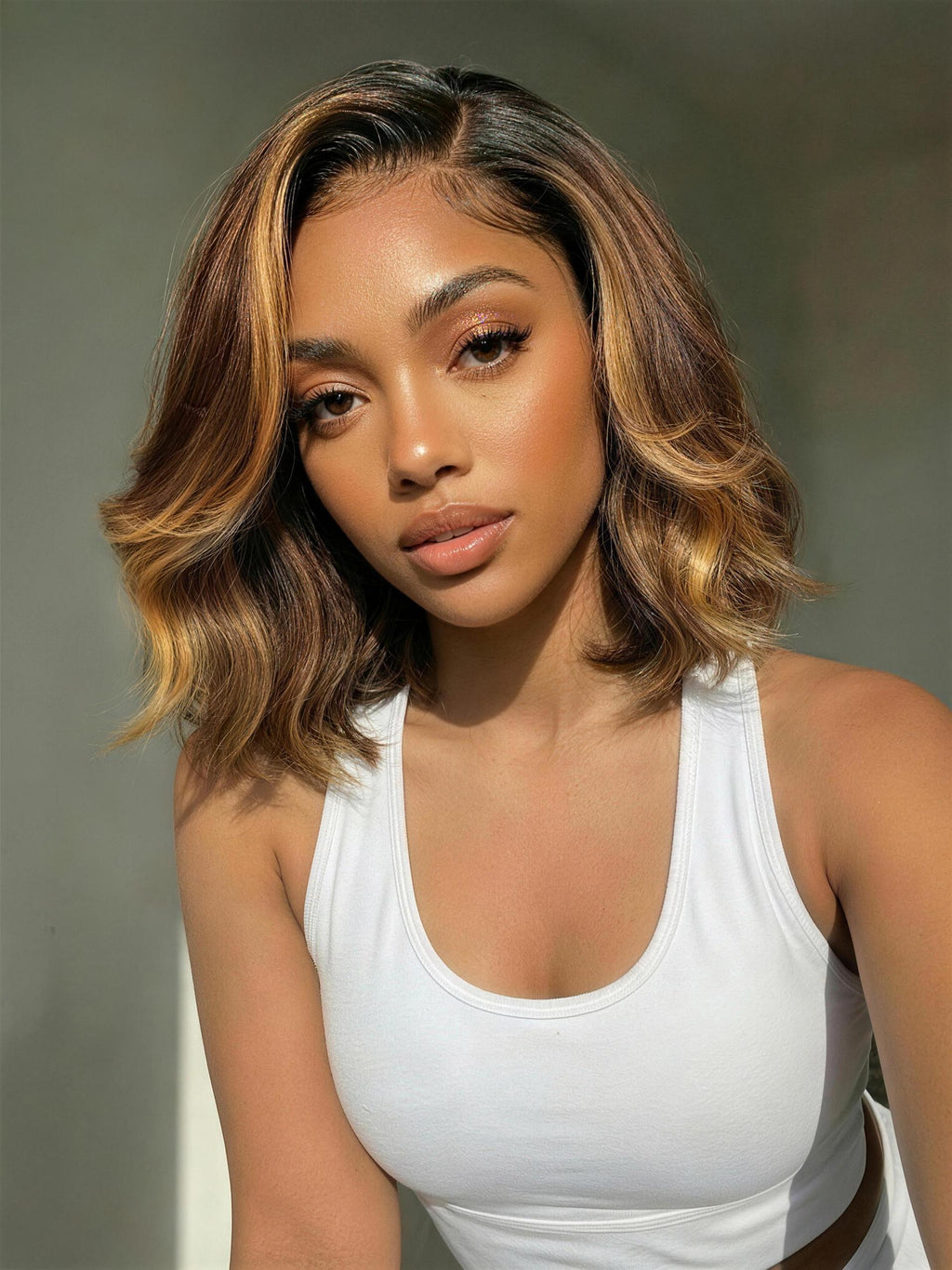 A model displays the UNice 7x5 & 13x4 Pre-Everything Lace Frontal Brown With Honey Blonde Face-Framing, showing a model with a white tank top and brown hair and honey.