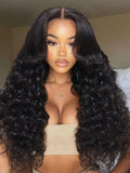 A model displays the UNice 20"-24" 13x4/7x5 Lace Yaki Loose Wave/Water Wave Curly/Loose Wave With bangs wig, showing a model with long curly hair wearing a tan colored.