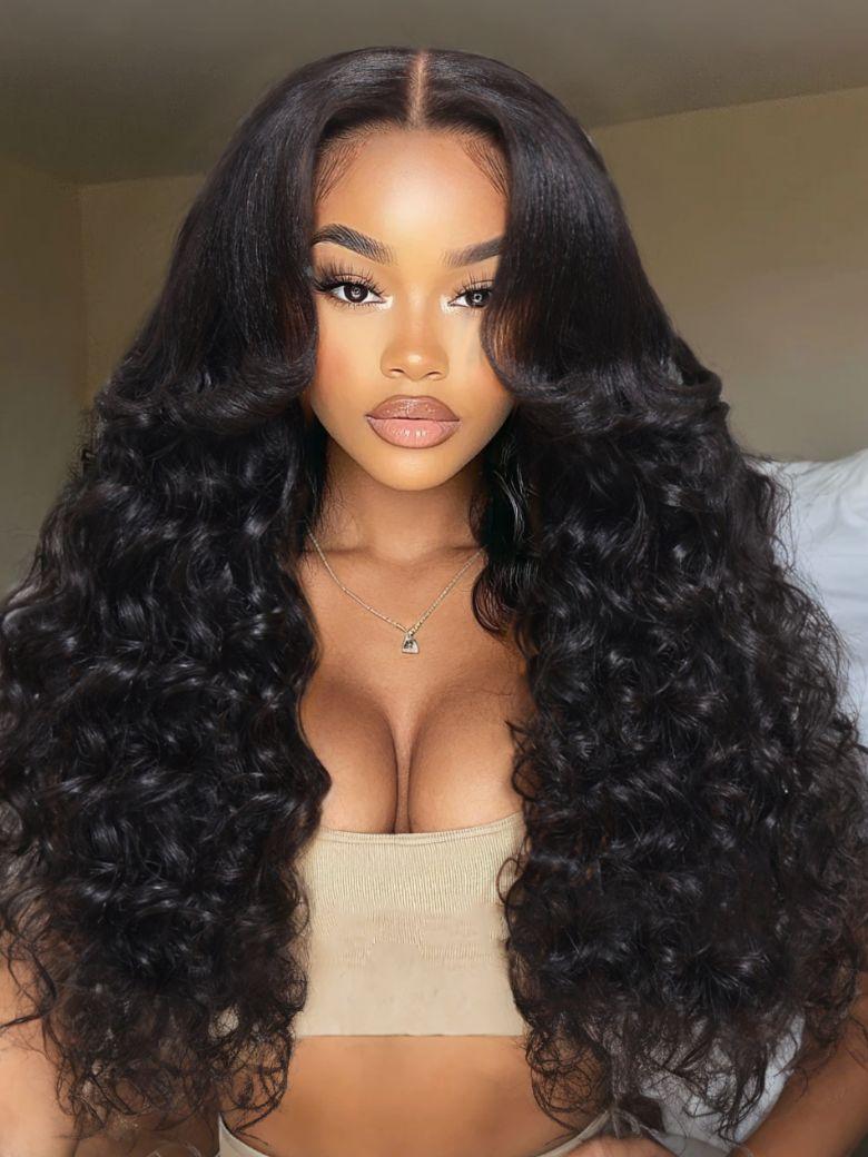 A model displays the UNice 20"-24" 13x4/7x5 Lace Yaki Loose Wave/Water Wave Curly/Loose Wave With bangs wig, showing a model with long curly hair wearing a tan colored.
