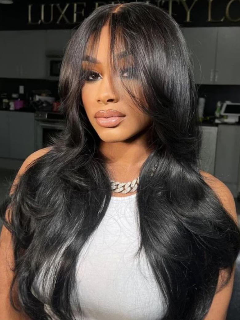 A model displays the UNice 180% Density 7x5 Byebye Knots Lace Frontal Fluffy Layer Natural Loose Wave Wig, showing a model with long black hair wearing a wig and loose.