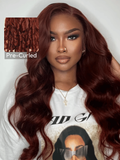 The UNice 7x5 Bye Bye Knots Wig Glueless Lace Reddish Brown Body Wave Bleached Knots Wig visual image position 3 shows a model with long red hair wearing a white shirt |.